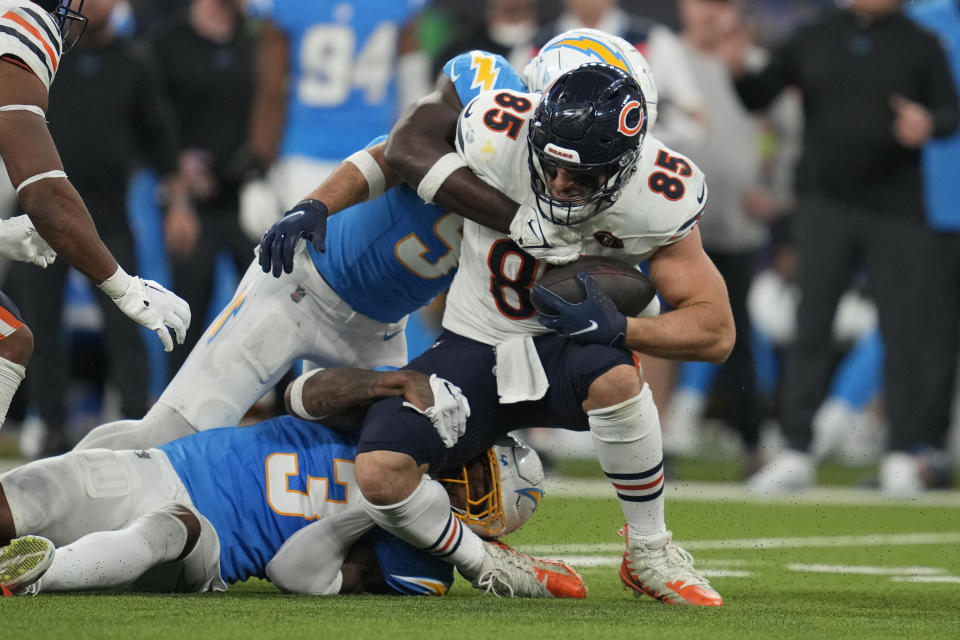 Chicago Bears tight end Cole Kmet, center, is hauled down by Los Angeles Chargers linebacker Kenneth Murray Jr., above, and safety Derwin James Jr. during the second half of an NFL football game Sunday, Oct. 29, 2023, in Inglewood, Calif. (AP Photo/Ashley Landis)