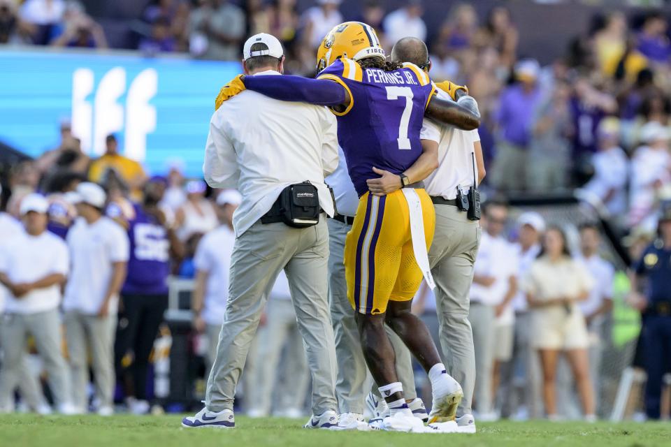 LSU linebacker Harold Perkins Jr. (7) is led off the field after a collision with UCLA wide receiver J. Michael Sturdivant (7) during the second half of an NCAA football game, Saturday, Sept. 21, 2024, in Baton Rouge, Louisiana. (AP Photo/Matthew Hinton)