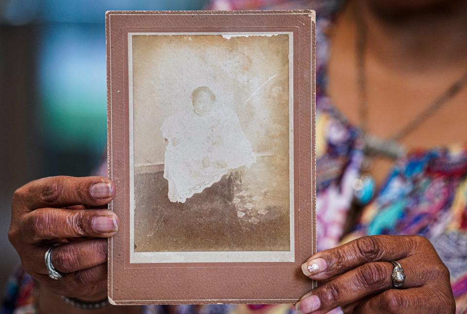 Siobhan Guy, the granddaughter of Georgia Hardrick Stewart, who was the younger sister of painter John Wesley Hardrick, holds a photo of the famous artist as a baby.