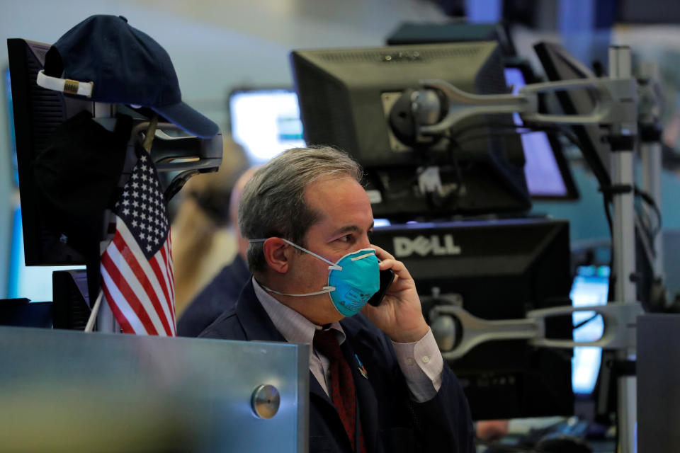 A trader wears a face mask on the floor of the New York Stock Exchange (NYSE) following traders testing positive for Coronavirus disease (COVID-19), in New York, U.S., March 19, 2020. REUTERS/Lucas Jackson     TPX IMAGES OF THE DAY