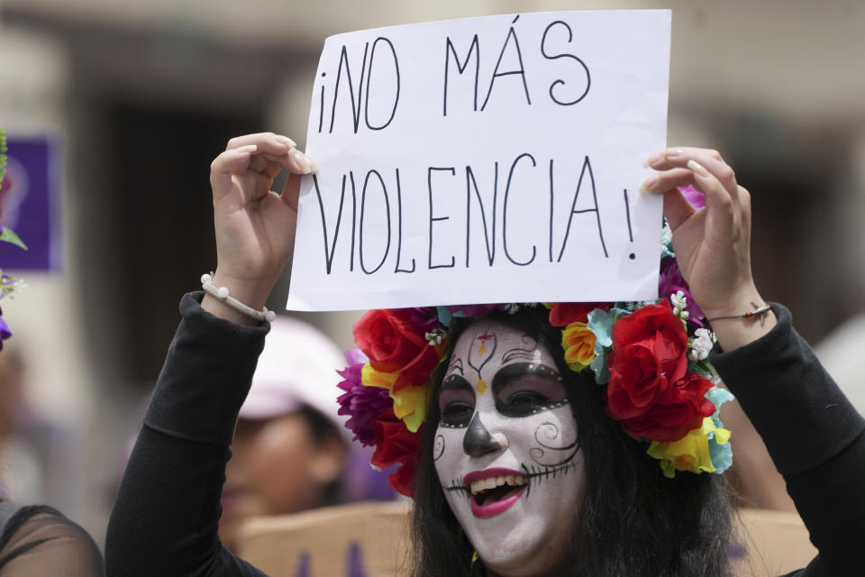 Una mujer sostiene un cartel con un mensaje que dice "¡No más violencia!" durante una marcha para conmemorar el Día Internacional de la Eliminación de la Violencia contra la Mujer, en Quito, Ecuador, el sábado 25 de noviembre de 2023. (AP Foto/Dolores Ochoa)