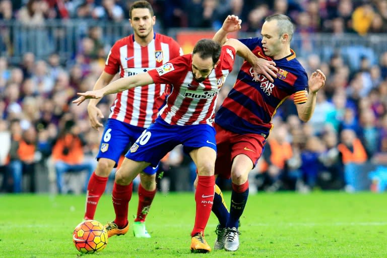 Atletico Madrid's Juanfran (L) fights for the ball with Barcelona's Andres Iniesta during their Spanish La Liga match, at the Camp Nou stadium in Barcelona, on January 30, 2016