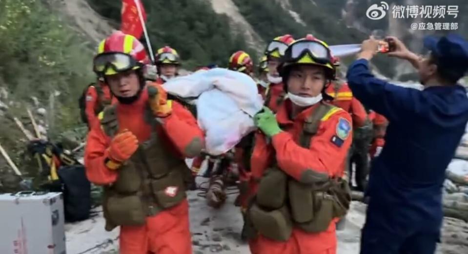 中國四川省瀘定縣5日發生規模6.8地震，搜救隊協助受傷民眾移動。   圖：翻攝微博