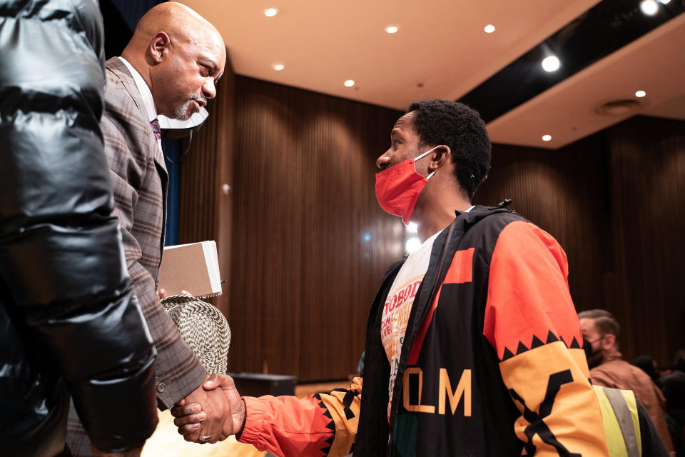 Image: Reverend Jerry McAfee shakes hands with an audience member at the North High School auditorium in Minneapolis on Oct. 12, 2021. (Drew Arrieta for NBC News)