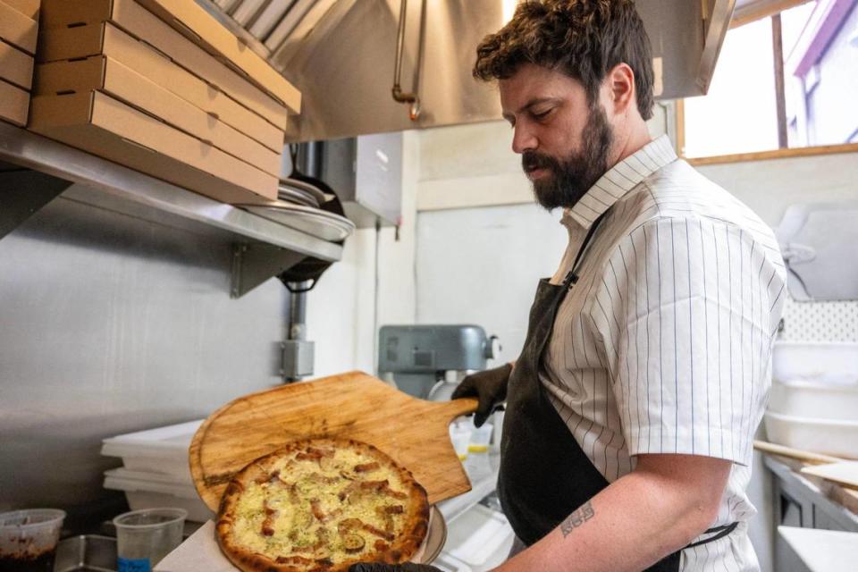Justin Norcross, owner of Fortunati Pizza, plates a 12-inch baked potato pizza. He opened the restaurant last summer.