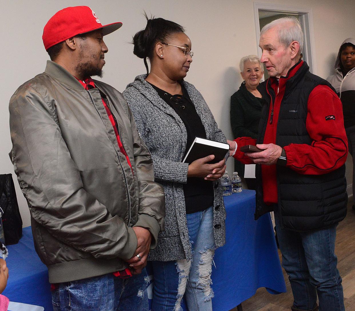 Lawrence and Kelly Williams receive the keys to their new home on Noble Street in Alliance from Alliance Area Habitat for Humanity Board Member John McIntosh on Sunday, Dec. 17, 2023, during the agency's dedication ceremony for the Apostle Build project.