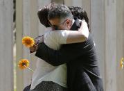 Mourners embrace as they attend a memorial event to victims of the July 7, 2005 London bombings, at the memorial in Hyde Park, central London, Britain July 7, 2015. Britain fell silent on Tuesday to commemorate the 10th anniversary of attacks targeting London public transport which killed 56 people, the first suicide bombings by Islamist militants in western Europe. (REUTERS/Peter Nicholls)