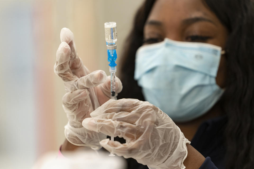 FILE - In this Thursday, March 11, 2021, file photo, a health worker loads syringes with the vaccine on the first day of the Johnson & Johnson vaccine being made available to residents at the Baldwin Hills Crenshaw Plaza in Los Angeles. California officials say much of the state will be able to reopen next week to indoor activities as coronavirus case rates remain low. At the same time, more than 4 million residents with certain disabilities or health concerns become eligible for a vaccine. (AP Photo/Damian Dovarganes, File)