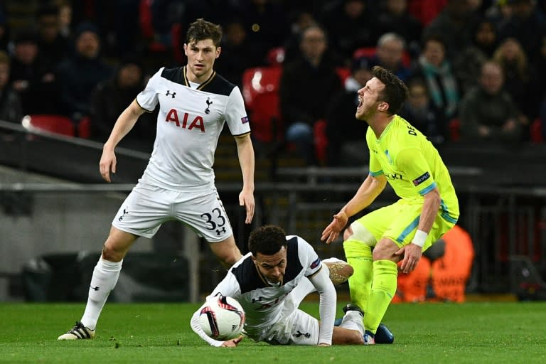 Tottenham midfielder Dele Alli (C) tackles Gent's Brecht Dejaegere earning a red card during the Europa League round of 32 second-leg at Wembley Stadium in north London, on February 23, 2017