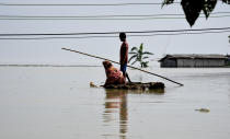 Villagers cross a flooded area on a makeshift raft, in Panikhaiti village, in Kamrup District, Assam, India on Tuesday, on July 14, 2020. Villages in Assam were flooded due to heavy rains. The rising water level inundated houses, residents were forced to move to a safer place. (Photo by Hafiz Ahmed/Anadolu Agency via Getty Images)