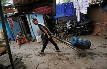 A girl carries a water container after filling it from a municipal tanker in New Delhi, India, June 26, 2018. Picture taken June 26, 2018. REUTERS/Adnan Abidi