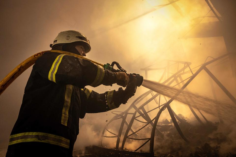 A firefighter fights a fire after Russian attacks struck a warehouse in the suburbs of Kyiv on March 24, 2022. (Photo by FADEL SENNA / AFP) (Photo by FADEL SENNA/AFP via Getty Images)