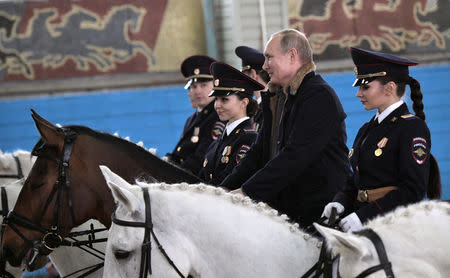 Russian President Vladimir Putin (2nd R) rides a horse as he attends a meeting with female officers of a mounted police unit to congratulate them on the upcoming International Women's Day in Moscow, Russia March 7, 2019. Sputnik/Alexei Nikolsky/Kremlin via REUTERS