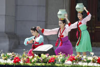 An art troupe performs in front of the Pyongyang Grand Theatre in Pyongyang, North Korea, Tuesday, July 27, 2021, to mark the Korean War armistice anniversary. The leaders of North and South Korea restored suspended communication channels between them and agreed to improve ties, both governments said Tuesday, amid a 2 ½ year-stalemate in U.S.-led diplomacy aimed at stripping North Korea of its nuclear weapons. (AP Photo/Cha Song Ho)