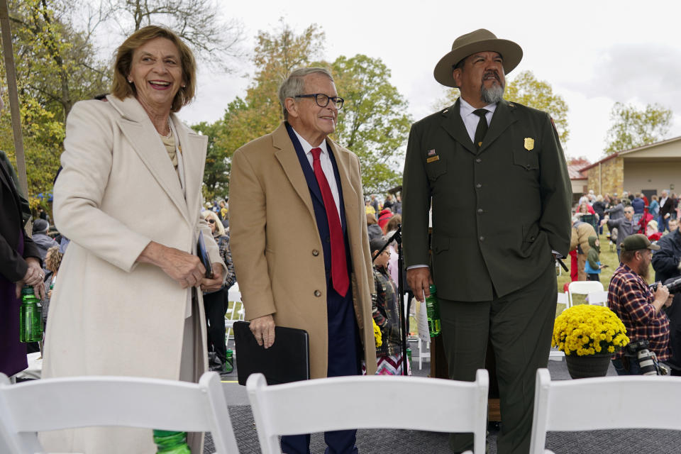 Ohio Gov. Mike DeWine, center, and his spouse, Frances, and National Park Service Director Chuck Sams, right, look out over the Mound City Group at Hopewell Culture National Historical Park in Chillicothe, Ohio, Saturday, Oct. 14, 2023, after the Hopewell Ceremonial Earthworks UNESCO World Heritage Inscription Commemoration ceremony. A network of ancient American Indian ceremonial and burial mounds in Ohio noted for their good condition, distinct style and cultural significance, including Hopewell, was added to the list of UNESCO World Heritage sites. (AP Photo/Carolyn Kaster)
