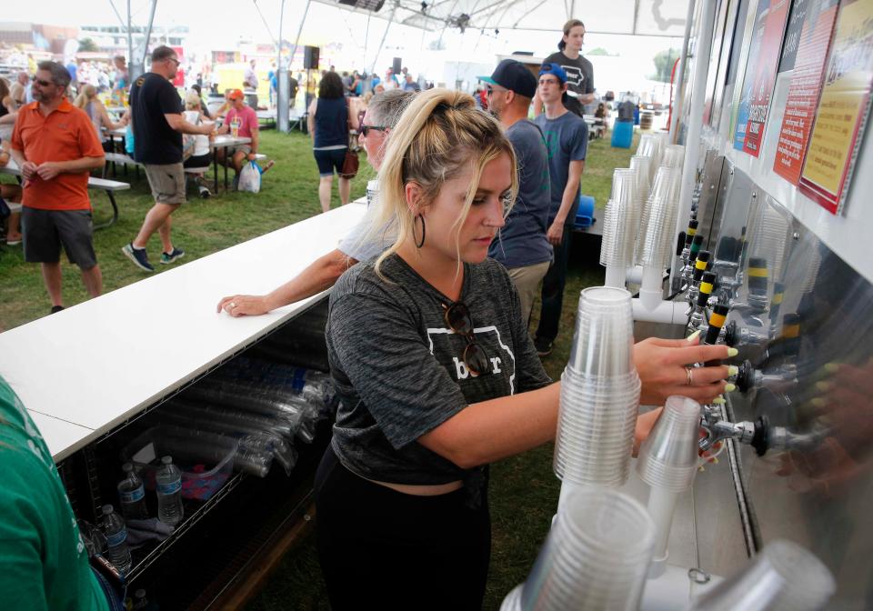 Sam Fitzgerald of Des Moines pours an Iowa-brewed beer at the Iowa Craft Beer Tent at the Iowa State Fair in Des Moines in 2021.