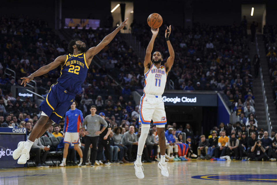 Oklahoma City Thunder guard Isaiah Joe (11) shoots as Golden State Warriors forward Andrew Wiggins (22) defends during the second half of an NBA basketball game Thursday, Nov. 16, 2023, in San Francisco. (AP Photo/Loren Elliott)