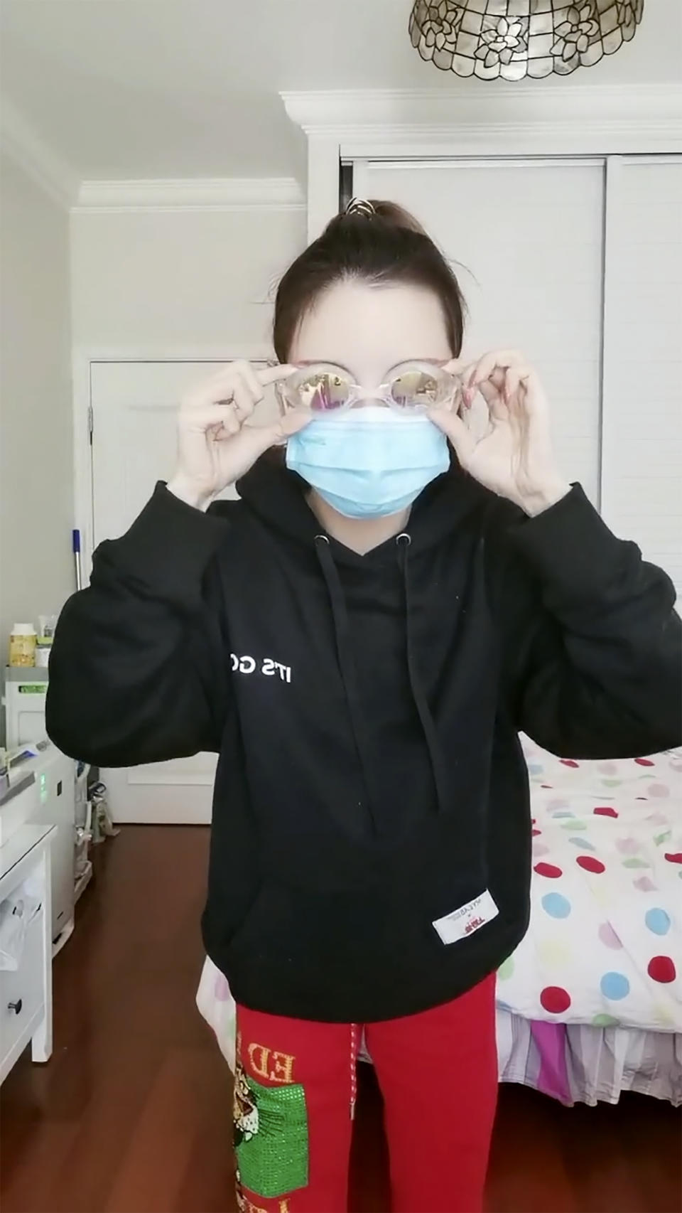 In this image taken from video provided by Grape Chen, Grape Chen puts on goggles before heading out for a COVID-19 test as part of a mass coronavirus testing effort in Shanghai, China, Monday, April 4, 2022. Anti-virus controls that shut down some of China's biggest cities and fueled public irritation are spreading as infections rise, hurting a weak economy and prompting warnings of possible global shockwaves. Chen said she is panicking about being able to obtain medication for her father, who is recovering from a stroke. She called police after getting no response from an official hotline but was told quarantine rules prevented officers from helping. (Grape Chen via AP)