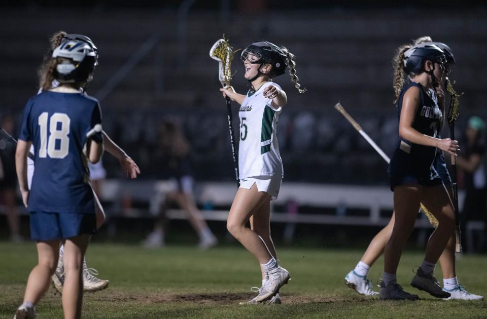 Ella Adams (15) celebrates scoring to take a 11-3 Crusaders lead during the Gulf Breeze vs Catholic girls lacrosse game at Pensacola Catholic High School on Friday, March 31, 2023.