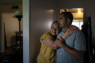 Ana Sandoval, mother of Eyvin Hernandez, a Los Angeles attorney who has been detained for five months in Venezuela, hugs her son Henry Martinez, Hernandez's half-brother, while posing for photos in Compton, Calif., Monday, Aug. 29, 2022. The Los Angeles attorney detained for five months in Venezuela is pleading for help from the Biden administration, saying in a secretly recorded jailhouse message that he feels forgotten by the U.S. government as he faces criminal charges at the hands of one of the nation's top adversaries. (AP Photo/Jae C. Hong)