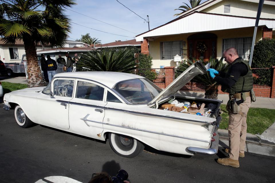 A member of the Los Angeles Sheriffs Dept. searches a vehicle during an investigation outside of a home in connection with a cold case in Los Angeles. Search warrants were served Wednesday at locations in California and Washington state in the investigation of the disappearance of Kristin Smart, the California Polytechnic State University, San Luis Obispo student who disappeared in 1996.