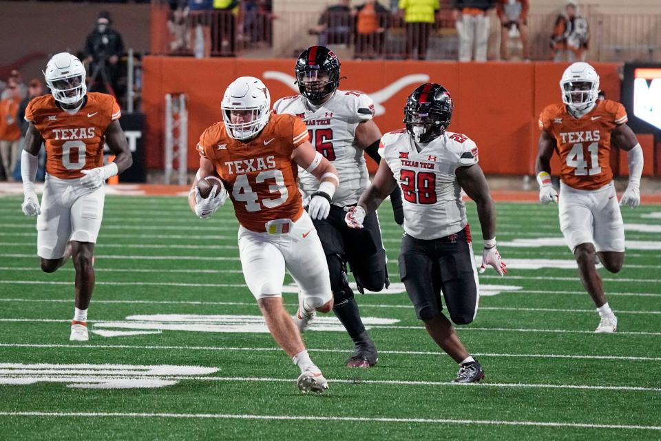 Texas linebacker Jett Bush (43) runs in to the end zone after making an interception during the second half against Texas Tech at Darrell K Royal-Texas Memorial Stadium.