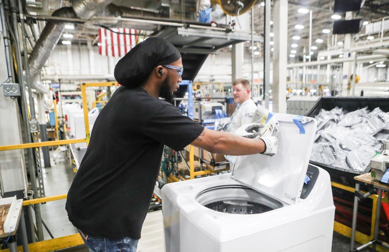 GE workers put the information stickers on a new GE 4.5 cubic ft. Capacity washing machine featuring a Spanish-language control panel and customized features at GE Appliance Park on April 15, 2024. GE is looking to capitalize on the the growing Spanish-speaking market in the U.S.