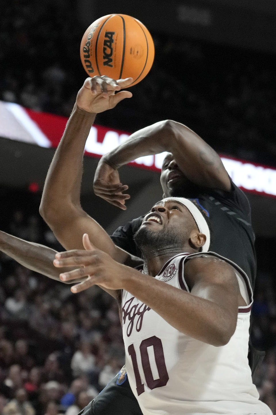 Memphis forward David Jones, top, blocks a shot-attempt by Texas A&M forward Wildens Leveque (10) during the first half of an NCAA college basketball game Sunday, Dec. 10, 2023, in College Station, Texas. (AP Photo/Sam Craft)