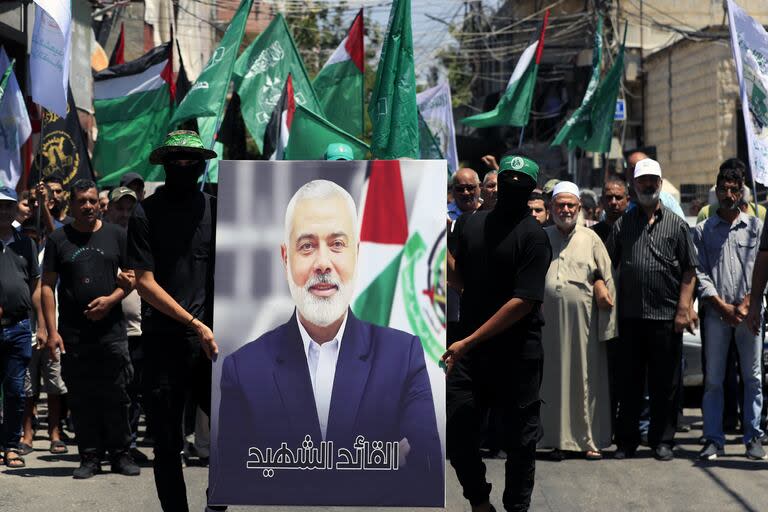 Miembros de Hamas sostienen un cartel del jefe político de Hamás, Ismail Haniyeh, durante una protesta para condenar su asesinato, en el campo de refugiados palestinos de al-Bass, en la ciudad portuaria meridional de Tiro, Líbano, miércoles 31 de julio de 2024.