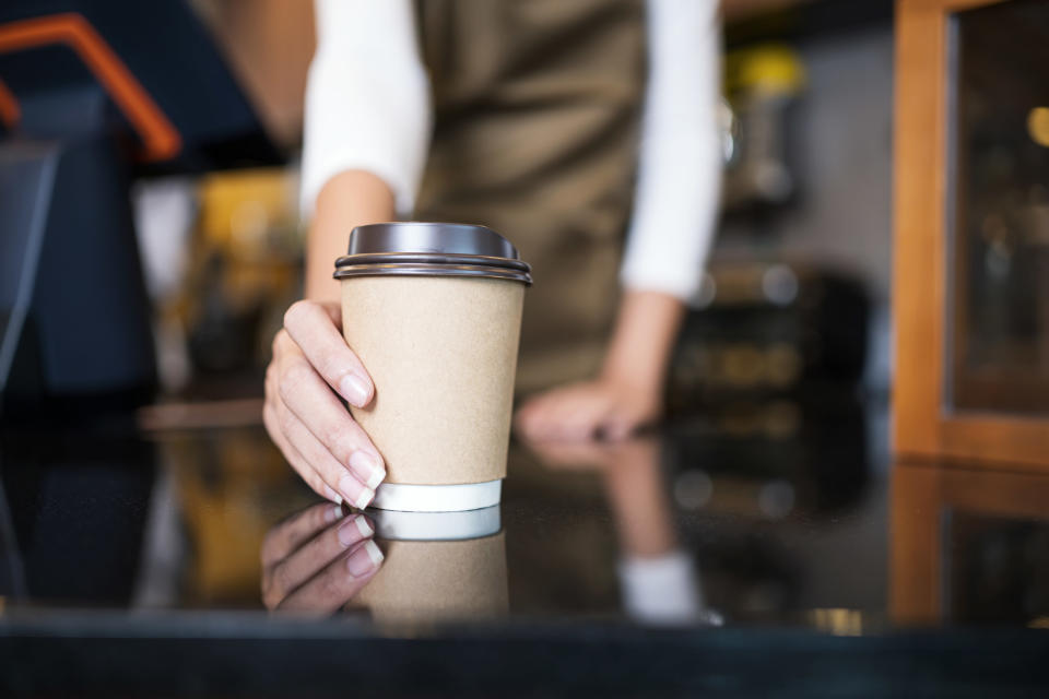 A barista holding a cup of coffee