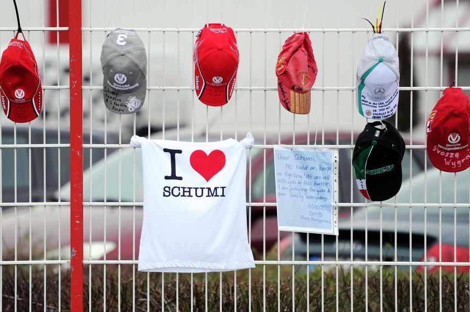 Schumacher fan caps, a fan T-shirt and a letter are attached on the fence at the Michael Schumacher Cart Center in his home town Kerpen, western Germany, Friday, Jan. 3, 2014. The Formula One record world champion is still in a coma after his skiing accident in France. (AP Photo/dpa, Marius Becker)