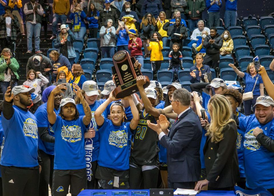 Delaware players hoist their CAA title trophy.