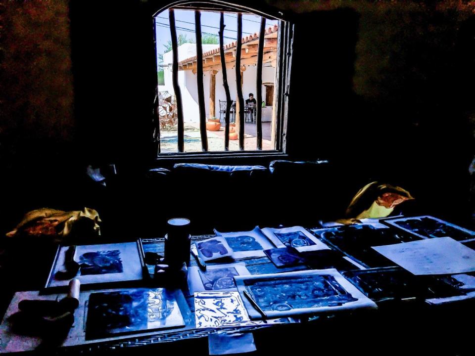 Printmaker Mario Alonso Perez is seen through the window at Casa Ortiz, the now defunct art gallery in Socorro. Samples of his work are in the foreground.