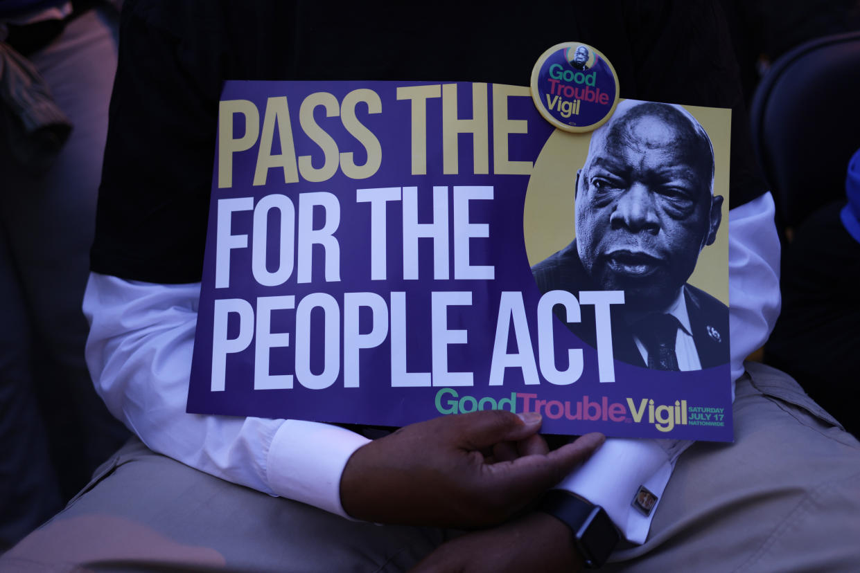 A voting rights activist holds a sign that reads 