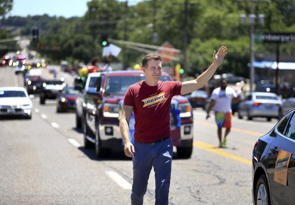 Lucas Kunce, a candidate who is seeking the Democratic nomination for the U.S. Senate, waves to people along West Florissant Ave. during the Dellwood Juneteenth Parade and Celebration on Sunday, June 19, 2022, in Dellwood, Mo. Kunce brings a Marine swagger and a grassroots populism that appeals to some, particularly in outstate Missouri. He has raised more money than any other candidate — Democrat or Republican — in each of the last four quarters. (David Carson/St. Louis Post-Dispatch via AP)