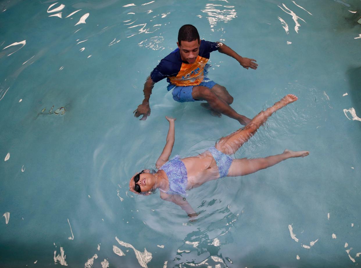 Leona Deguzman, 8, practices floating with guidance from her coach, Rodion Davelaar, at AQUAfin Swim School in Orange City on Thursday, Aug. 18. Davelaar, a former Olympian, and his wife opened the location in July.