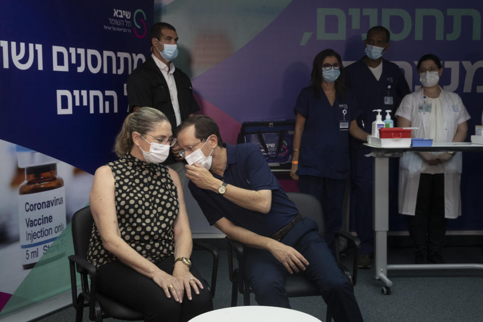 Israeli President Isaac Herzog speaks to his wife, Michal, left, before the couple received a third coronavirus vaccine at the Sheba Medical Center in Ramat Gan, Israel, Friday, July 30, 2021. (AP Photo/Maya Alleruzzo, Pool)