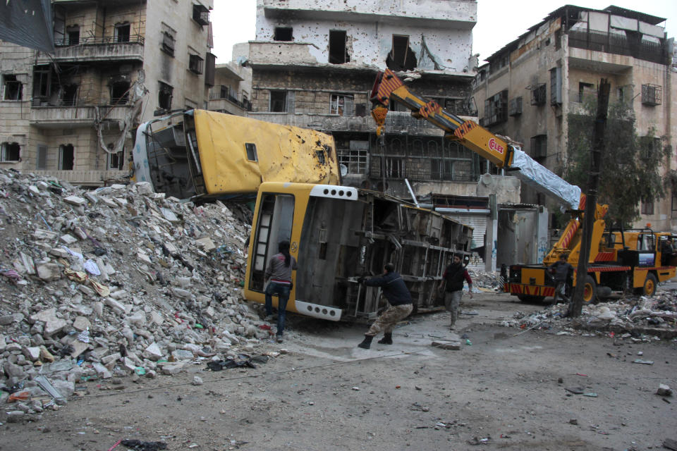 Rebel fighters fortify a barricade with destroyed public buses in the Salah al-Din neighbourhood of the northern Syrian city of Aleppo, December 4, 2013. (MEDO HALAB/AFP/Getty Images)