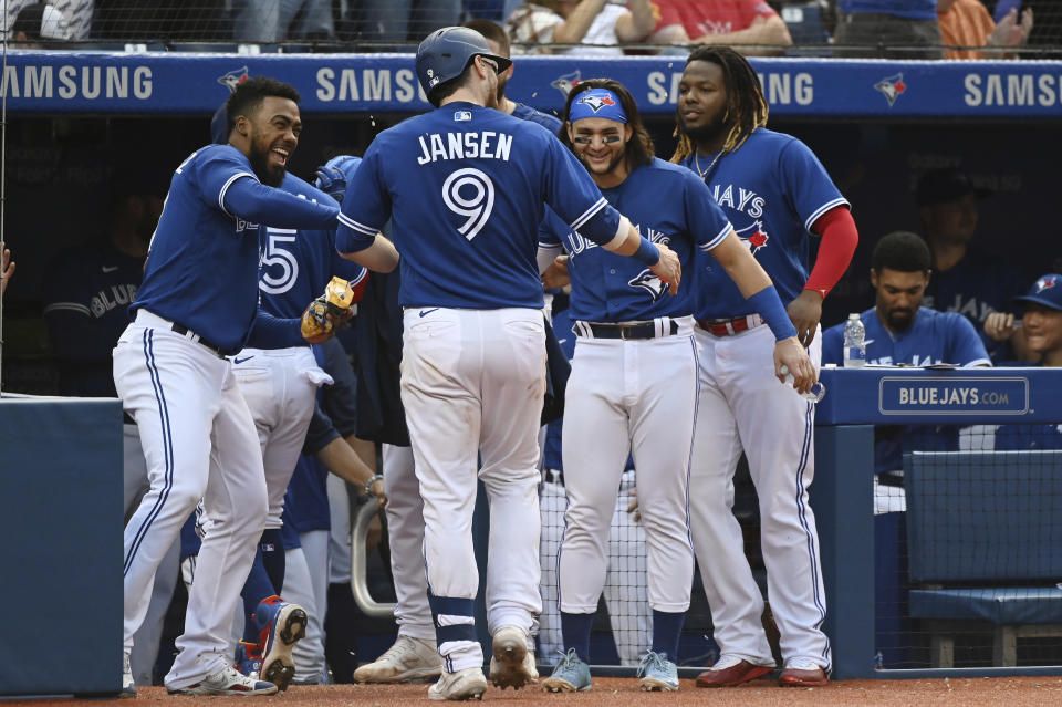 Toronto Blue Jays' Danny Jansen (9) celebrates with Teoscar Hernandez, left, Bo Bichette and Vladimir Guerrero Jr., right, after hitting a solo home run in the fifth inning of a baseball game against the Baltimore Orioles in Toronto, Saturday, Oct. 2, 2021. (Jon Blacker/The Canadian Press via AP)