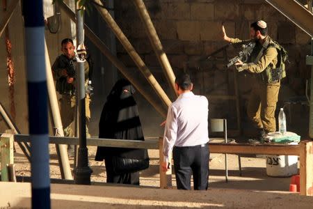 Israeli soldiers aim their rifles at a woman said to be 19-year-old Palestinian student Hadeel al-Hashlamun, before she was shot and killed by Israeli troops, at an Israeli checkpoint in the occupied West Bank city of Hebron September 22, 2015. The Israeli military said troops shot al-Hashlamun as she tried to stab a soldier. REUTERS/Youth Against Settlements Group/Handout via Reuters