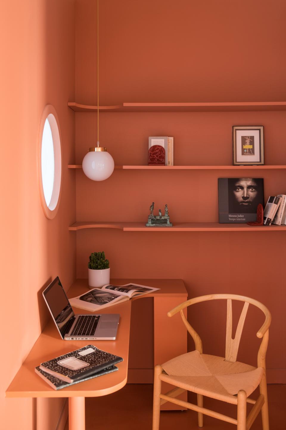 The original layout intended this small space to be the dining area, but CaSA thought it was too dark and cramped to work. So they made it into the “studio,” complete with a bespoke desk and a porthole window that brings in light from the master bedroom.