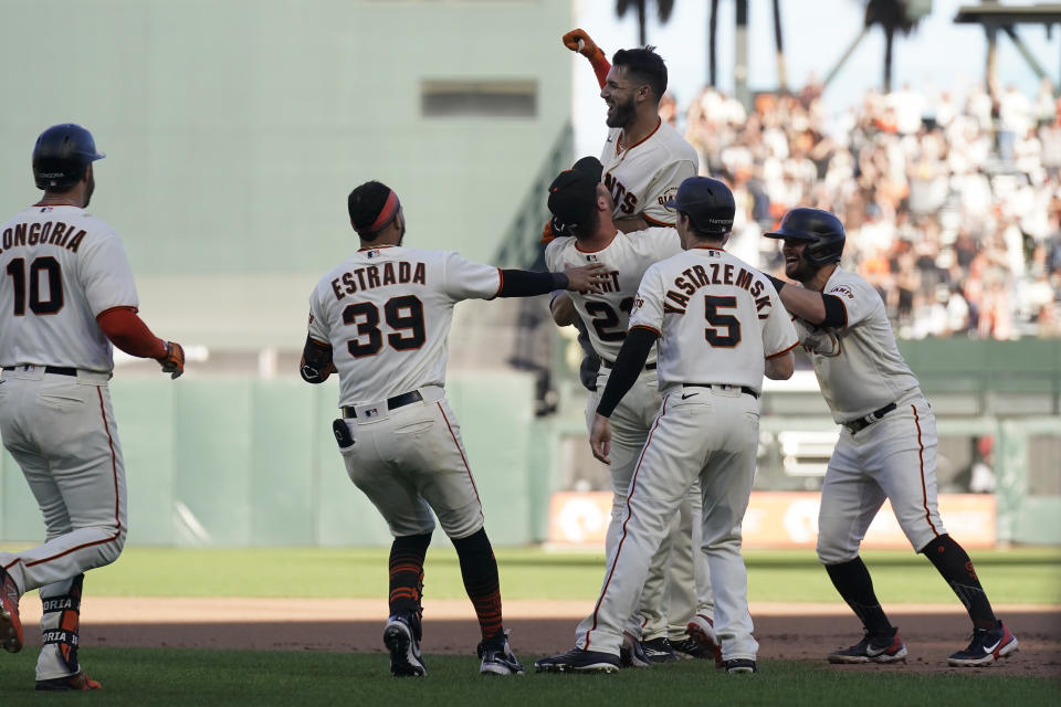 San Francisco Giants' David Villar, top, is congratulated by teammates after hitting a two-run single against the Arizona Diamondbacks during the 10th inning of a baseball game in San Francisco, Sunday, Oct. 2, 2022. (AP Photo/Jeff Chiu)