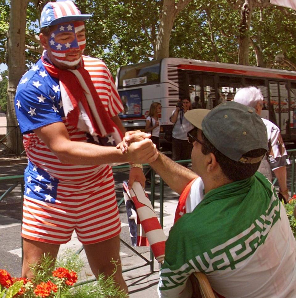 An US fan shakes hands with an Iranian supporter before kick-off in Lyon in 1998 - Gerard Cerles/AFP