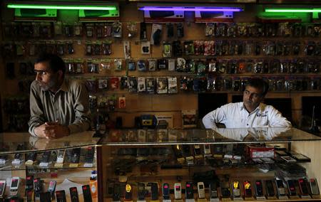 The owners of a mobile phone shop wait for customers in Marikana, Rustenberg April 2, 2014. REUTERS/Siphiwe Sibeko