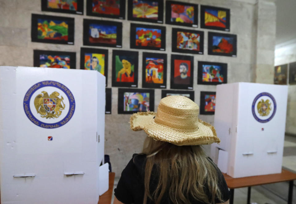 A woman waits to vote at a polling station during a parliamentary election in Yerevan, Armenia, Sunday, June 20, 2021. Armenians are voting in a national election after months of tensions over last year's defeat in fighting against Azerbaijan over the separatist region of Nagorno-Karabakh. (AP Photo/Sergei Grits)