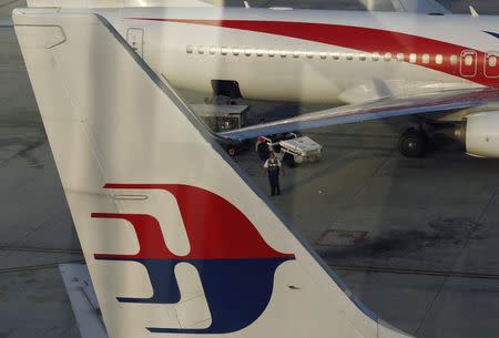 An airport worker walks between Malaysia Airlines planes at Kuala Lumpur International Airport July 25, 2014. REUTERS/Olivia Harris