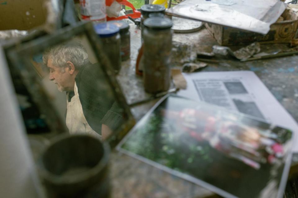 A profile of a man's face is reflected in the glass of a picture frame.