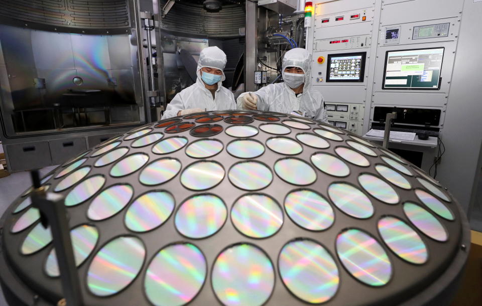 Employees work on the semiconductor chip production line of Jiangsu Azure Corp in Huaian, Jiangsu province, China March 25, 2022. China Daily via REUTERS ATTENTION EDITORS - THIS IMAGE WAS PROVIDED BY A THIRD PARTY. CHINA OUT.