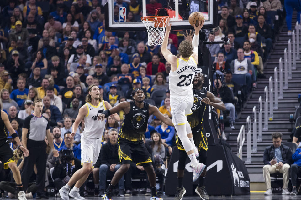 Utah Jazz forward Lauri Markkanen (23) shoots as Golden State Warriors center Kevon Looney (5) defends during the first half of an NBA basketball game in San Francisco, Friday, Nov. 25, 2022. (AP Photo/John Hefti)