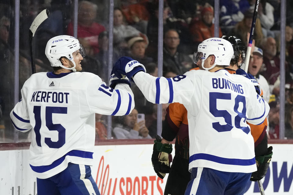 Toronto Maple Leafs center Alexander Kerfoot (15) celebrates after his goal against the Arizona Coyotes with Maple Leafs left wing Michael Bunting (58) during the second period of an NHL hockey game in Tempe, Ariz., Thursday, Dec. 29, 2022. (AP Photo/Ross D. Franklin)